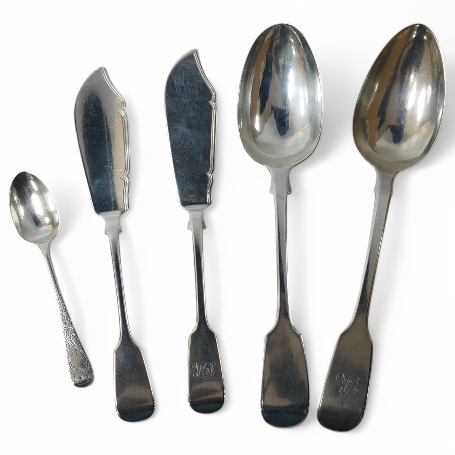 Four items of 19th century silver fiddle pattern flatware including two table spoons and two butter knives, together with a later silver teaspoon, 8.6oz. Condition - fair